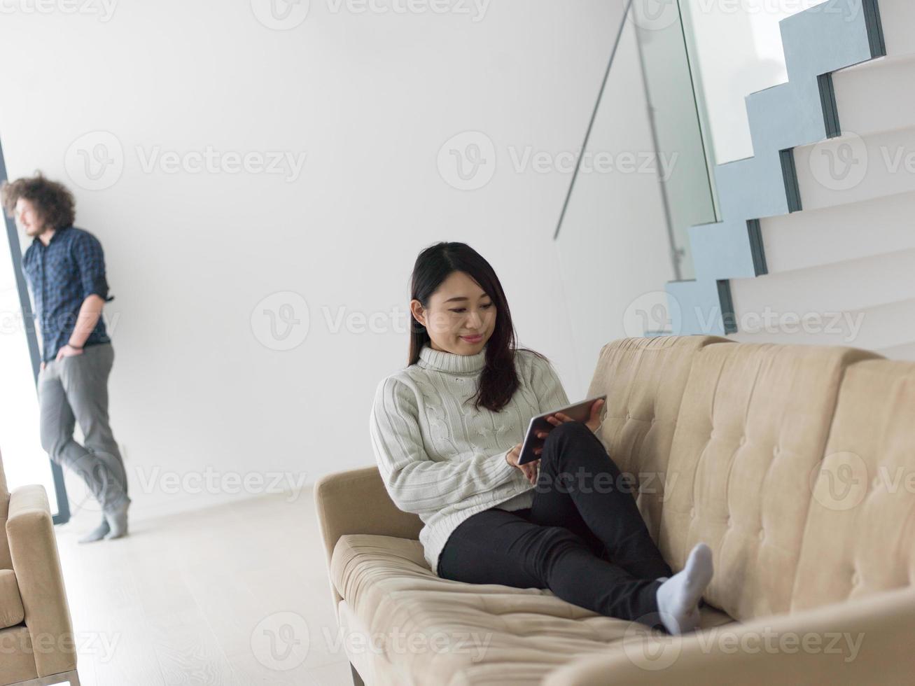 multiethnic couple at home using tablet computers photo