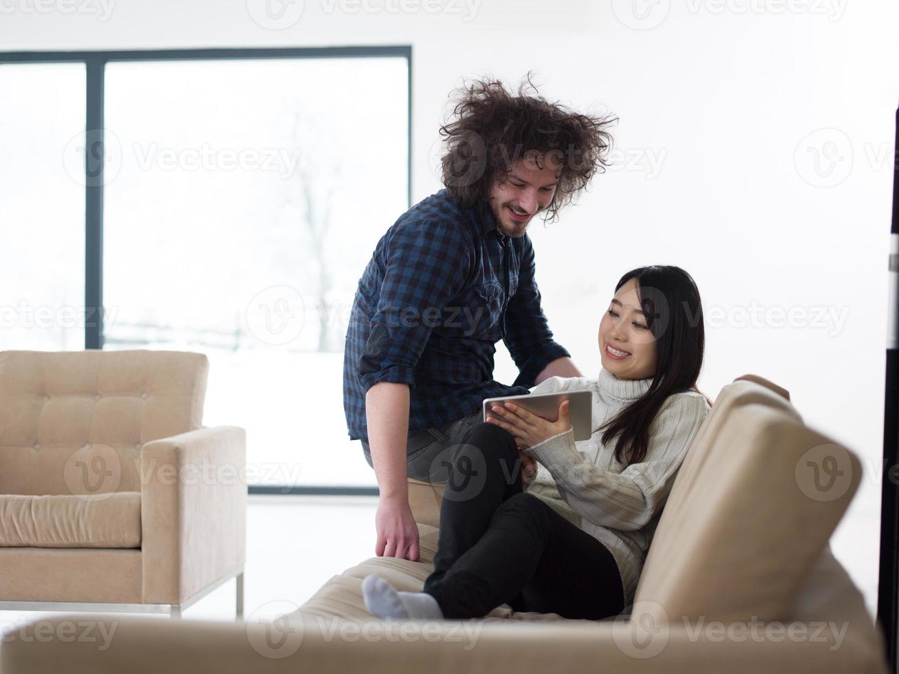 multiethnic couple at home using tablet computers photo