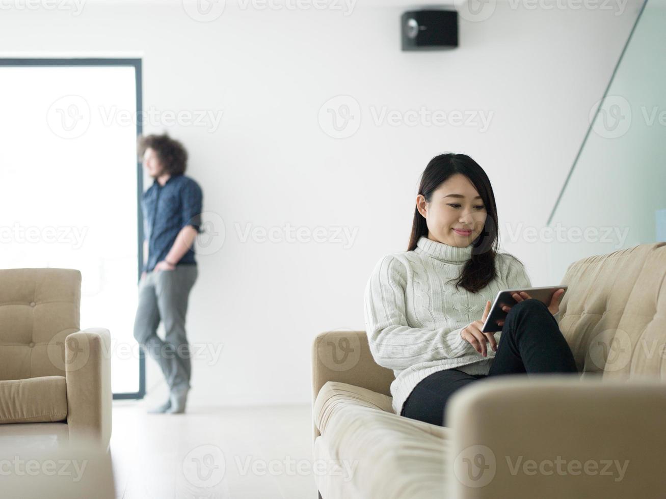 multiethnic couple at home using tablet computers photo