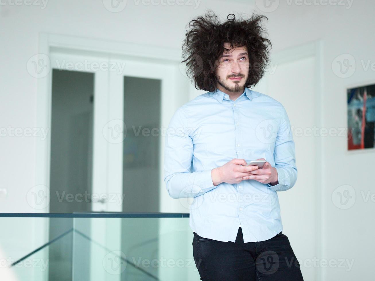 man using a mobile phone  at home photo