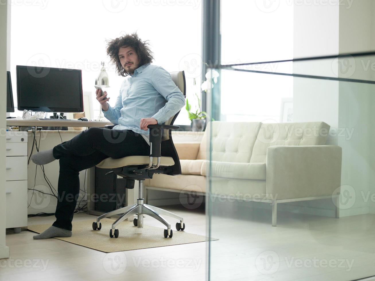 man using a mobile phone  at home photo