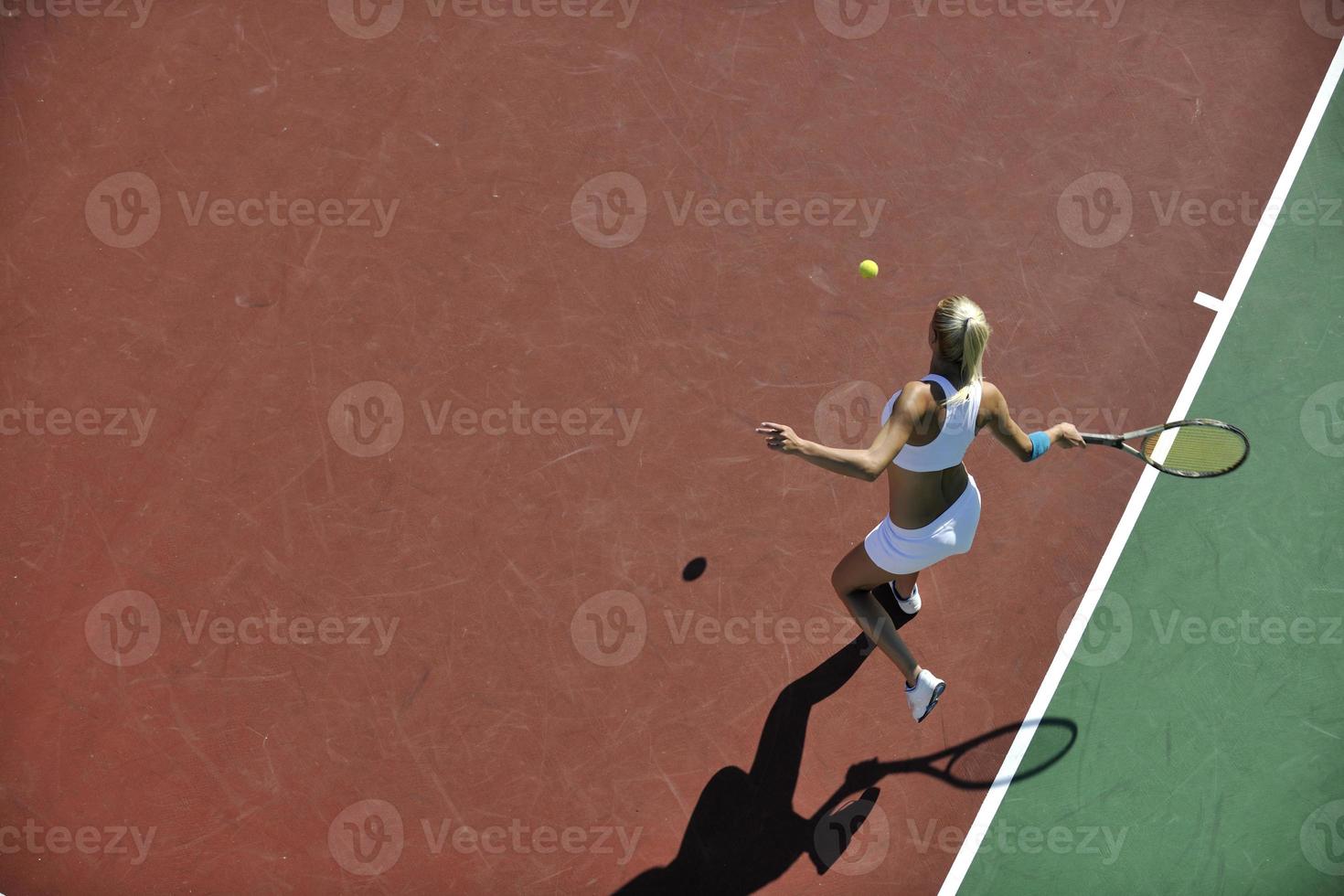 mujer joven jugar al tenis al aire libre foto