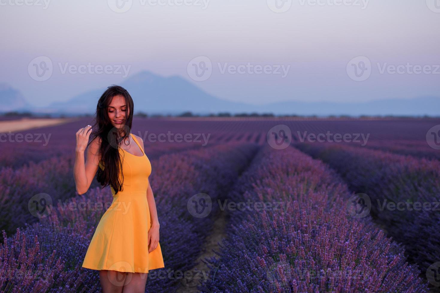 mujer con vestido amarillo en el campo de lavanda foto