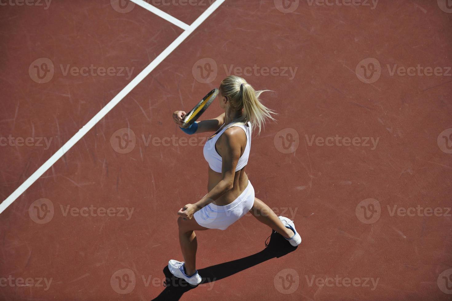 mujer joven jugar al tenis al aire libre foto