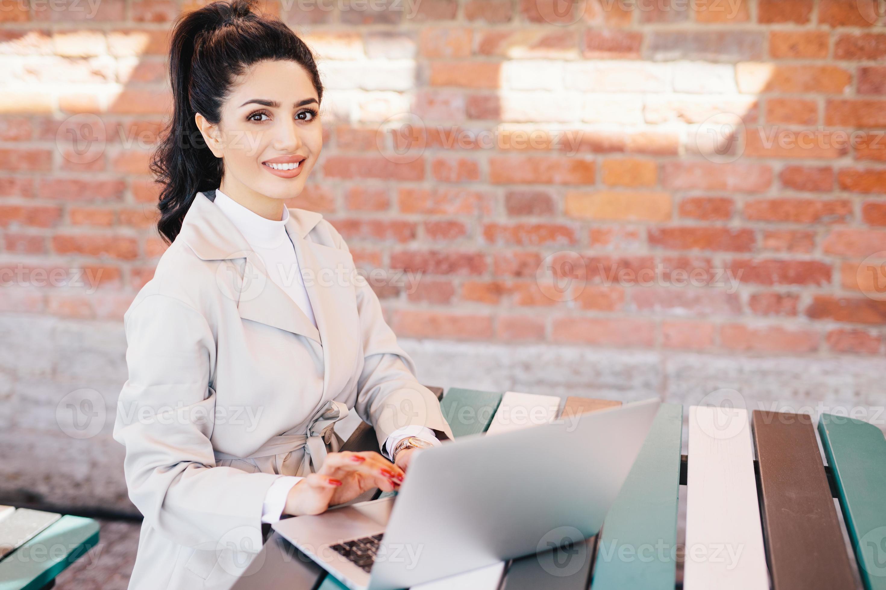 Pretty student female wearing elegant white coat working at