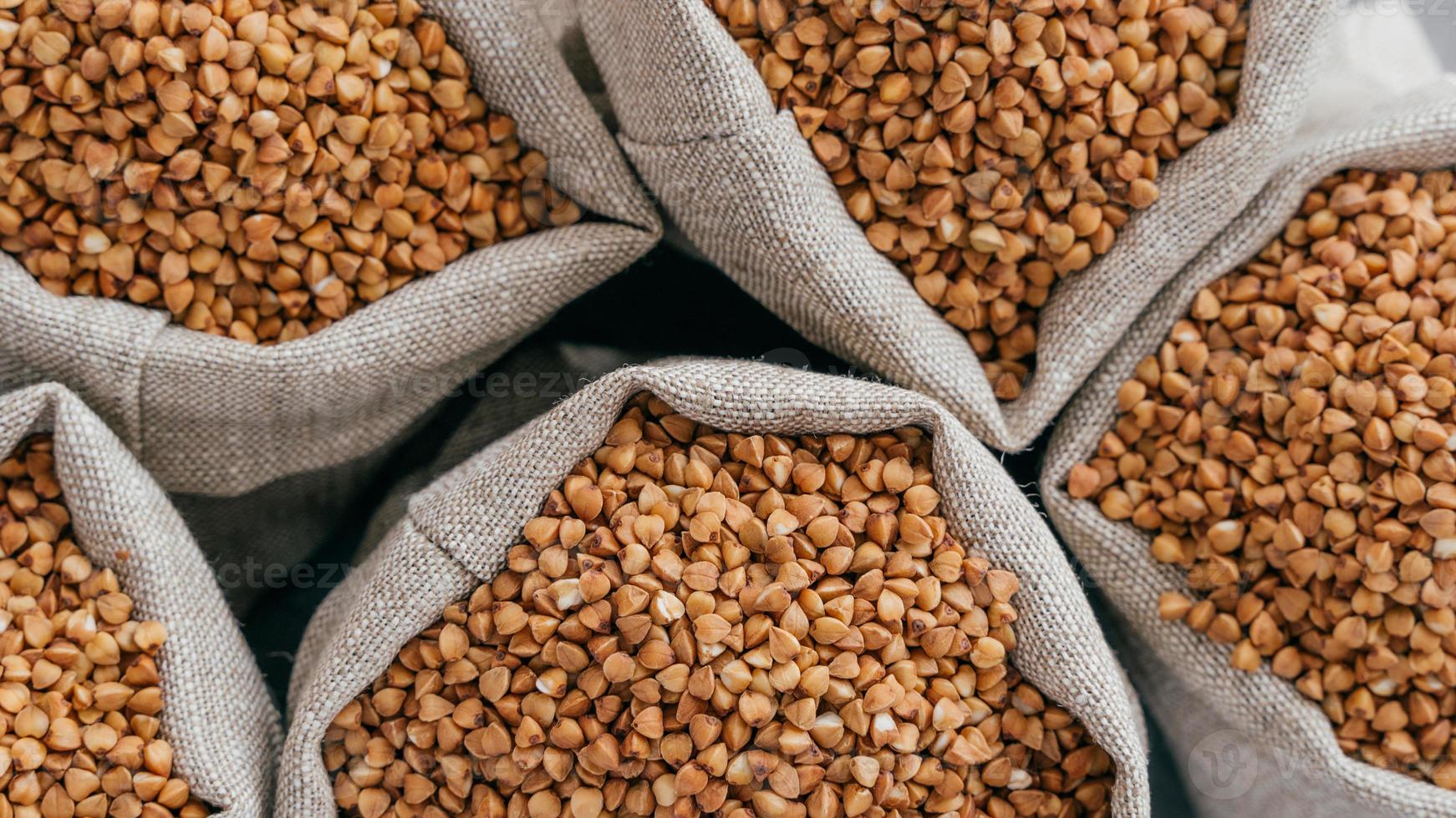 Food and healthy eating concept. Close up shot of raw buckwheat in sacks. Nurture. Dry healthy cereals. Food ingredients. Top view photo