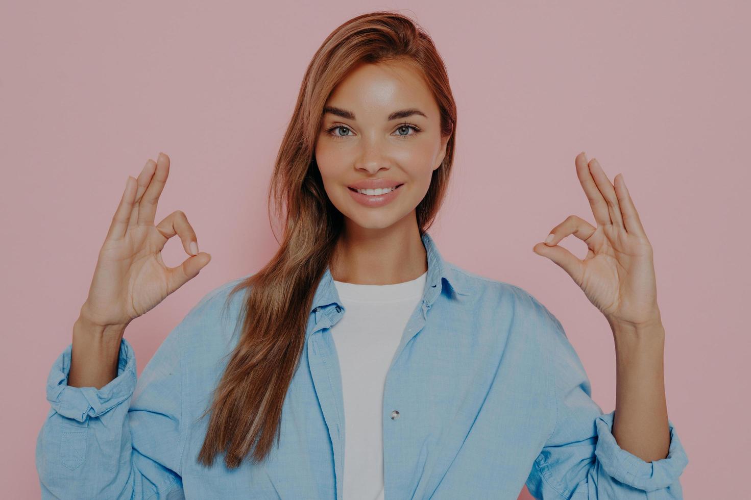 Beautiful woman showing okay gesture with both hands photo