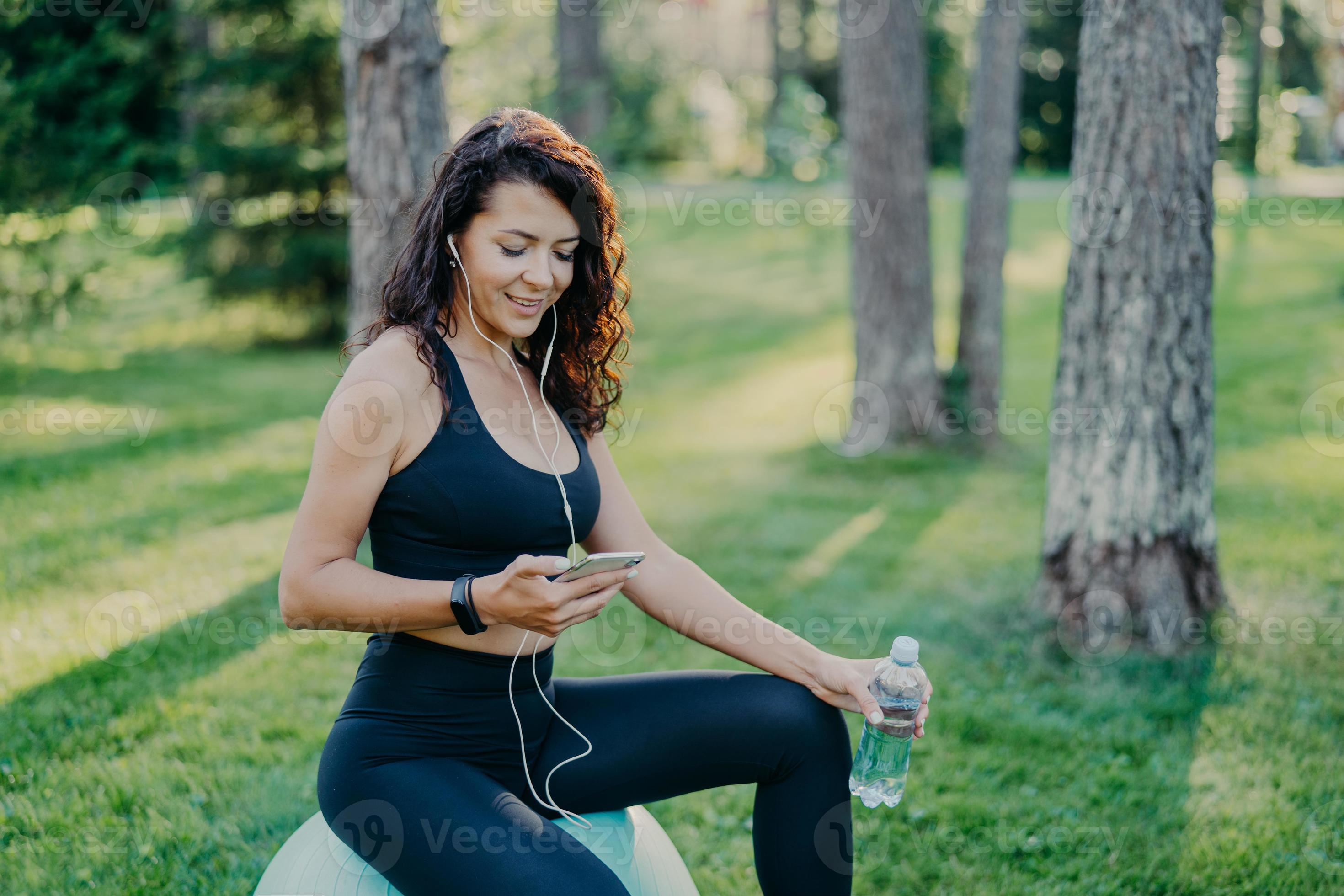 Photo of brunette sportswoman has rest after fitness training sits