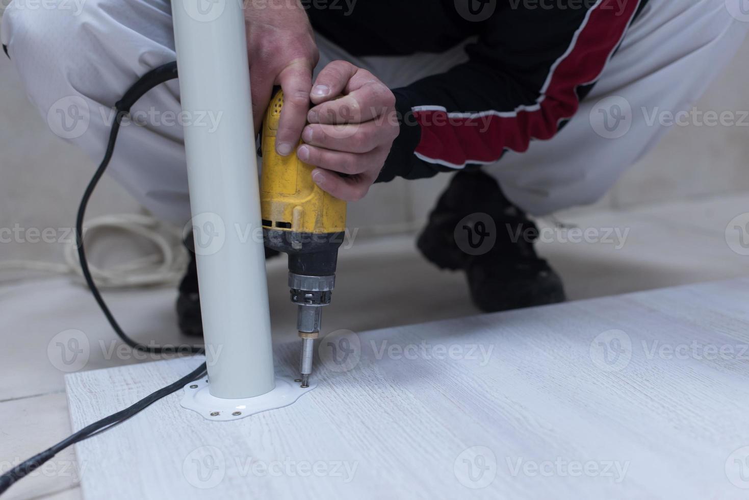 repairman working with drilling machine photo