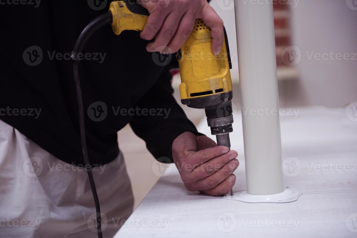 repairman working with drilling machine photo