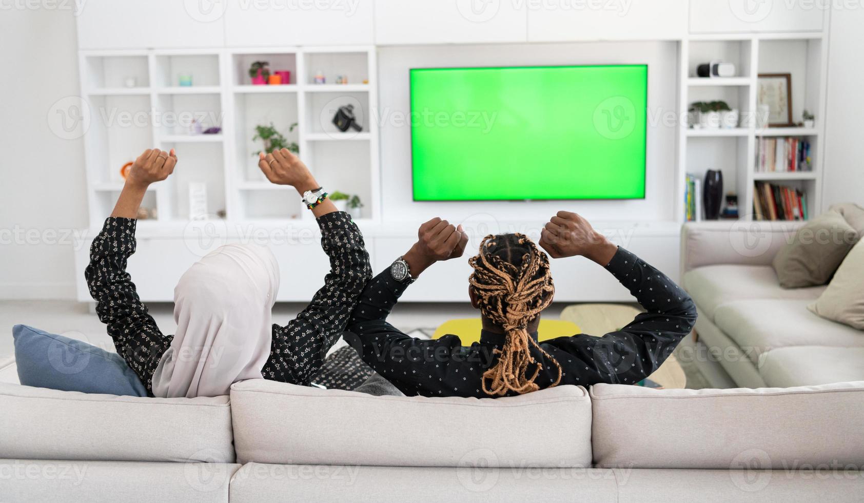 African Couple Sitting On Sofa Watching TV Together photo