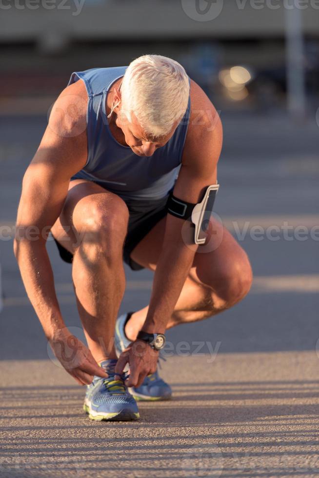 hombre atándose los cordones de las zapatillas foto