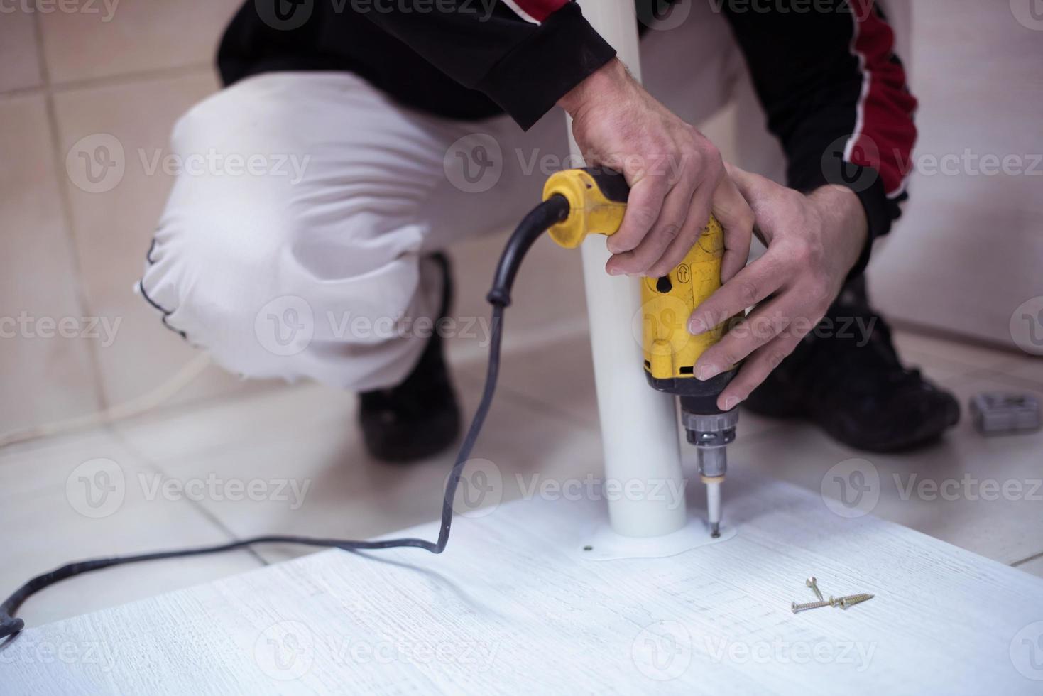 repairman working with drilling machine photo