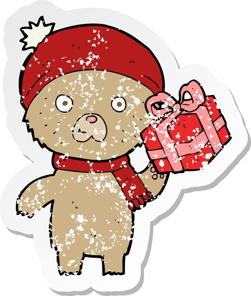 retro distressed sticker of a cartoon christmas teddy bear with present vector