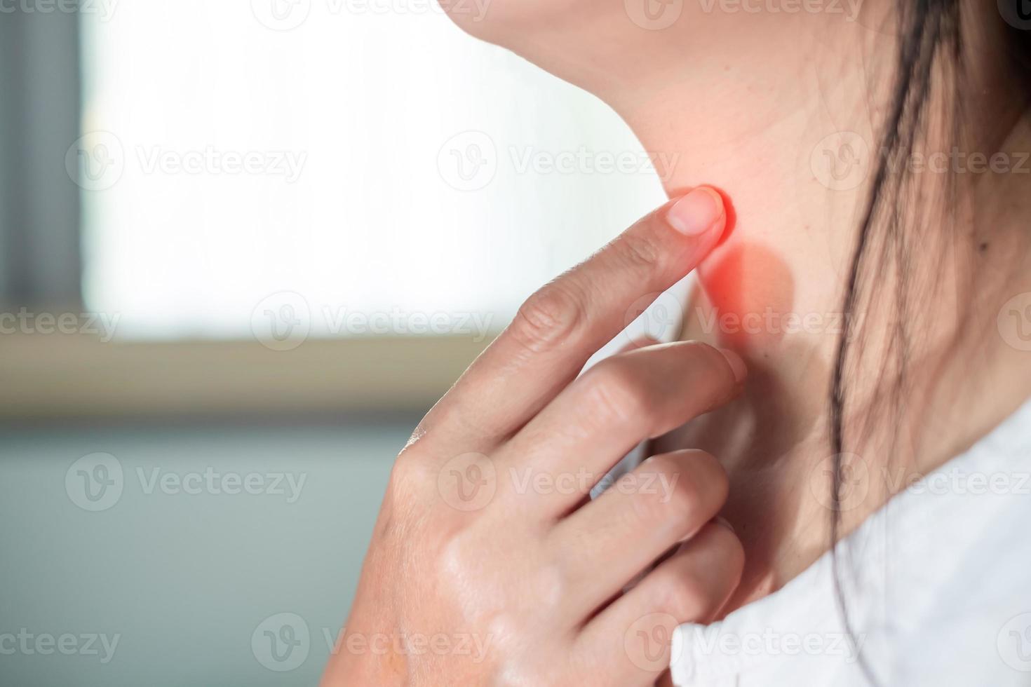 Close up woman scratch the neck by hand at home, due to itching in the throat, throat infection, flu, irritation. Healthcare and medical concept. photo