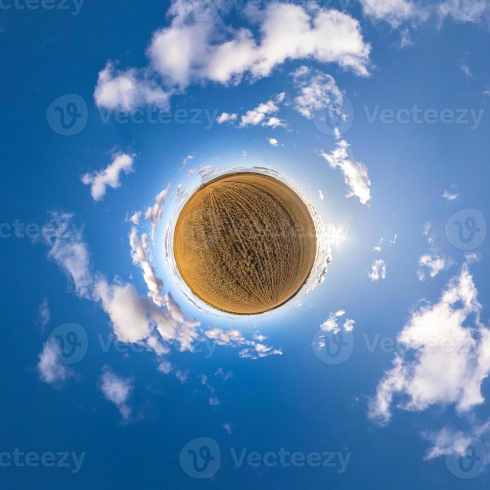 Little planet transformation of spherical panorama 360 degrees. Spherical abstract aerial view in field with awesome beautiful clouds. Curvature of space. photo