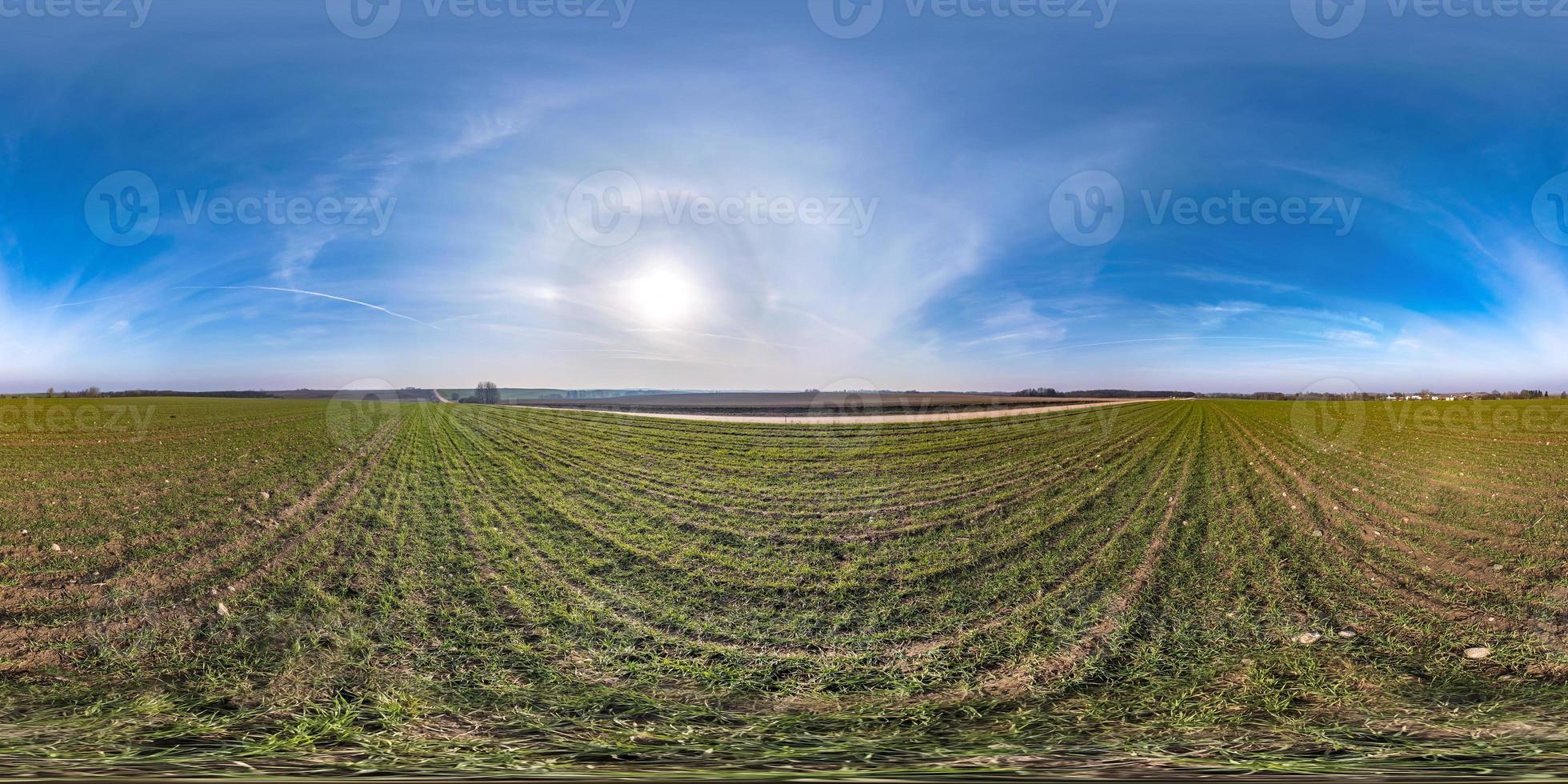 full seamless spherical hdri panorama 360 degrees angle view among fields in early spring day with sun on clear sky with halo in equirectangular projection, ready for VR AR content photo