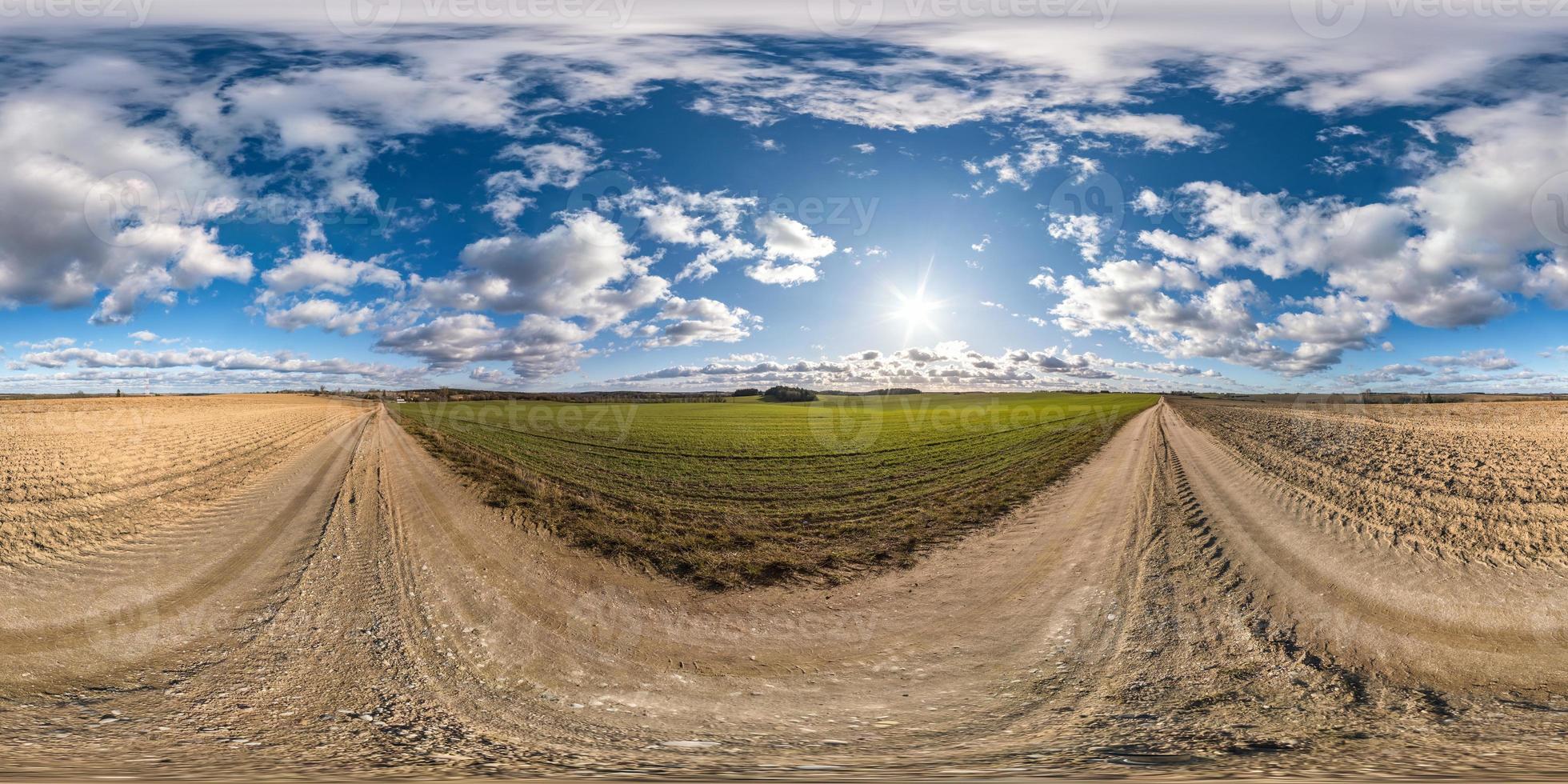 full seamless spherical hdri panorama 360 degrees angle view on gravel road among fields in spring day with awesome clouds in equirectangular projection, ready for VR AR virtual reality content photo
