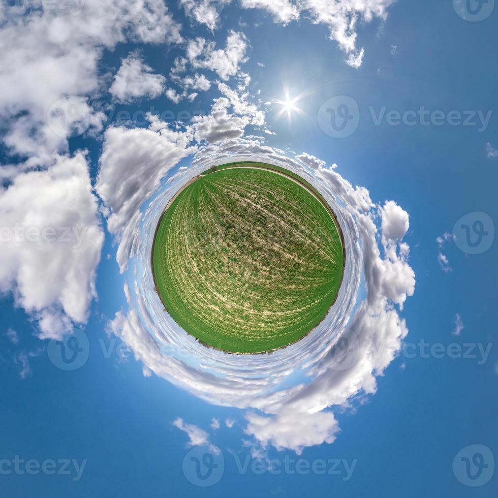 Little planet transformation of spherical panorama 360 degrees. Spherical abstract aerial view in field with awesome beautiful clouds. Curvature of space. photo