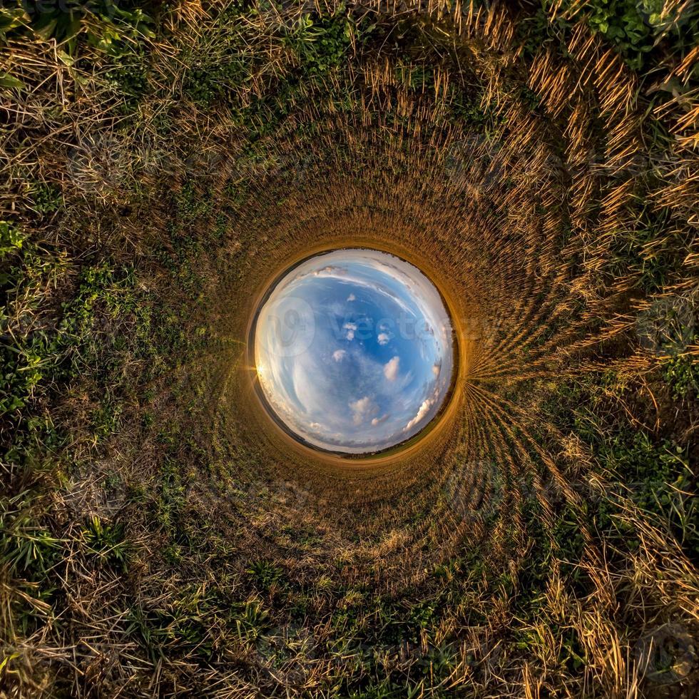 Inversion of little planet transformation of spherical panorama 360 degrees. Spherical abstract aerial view in field with awesome beautiful clouds. Curvature of space. photo