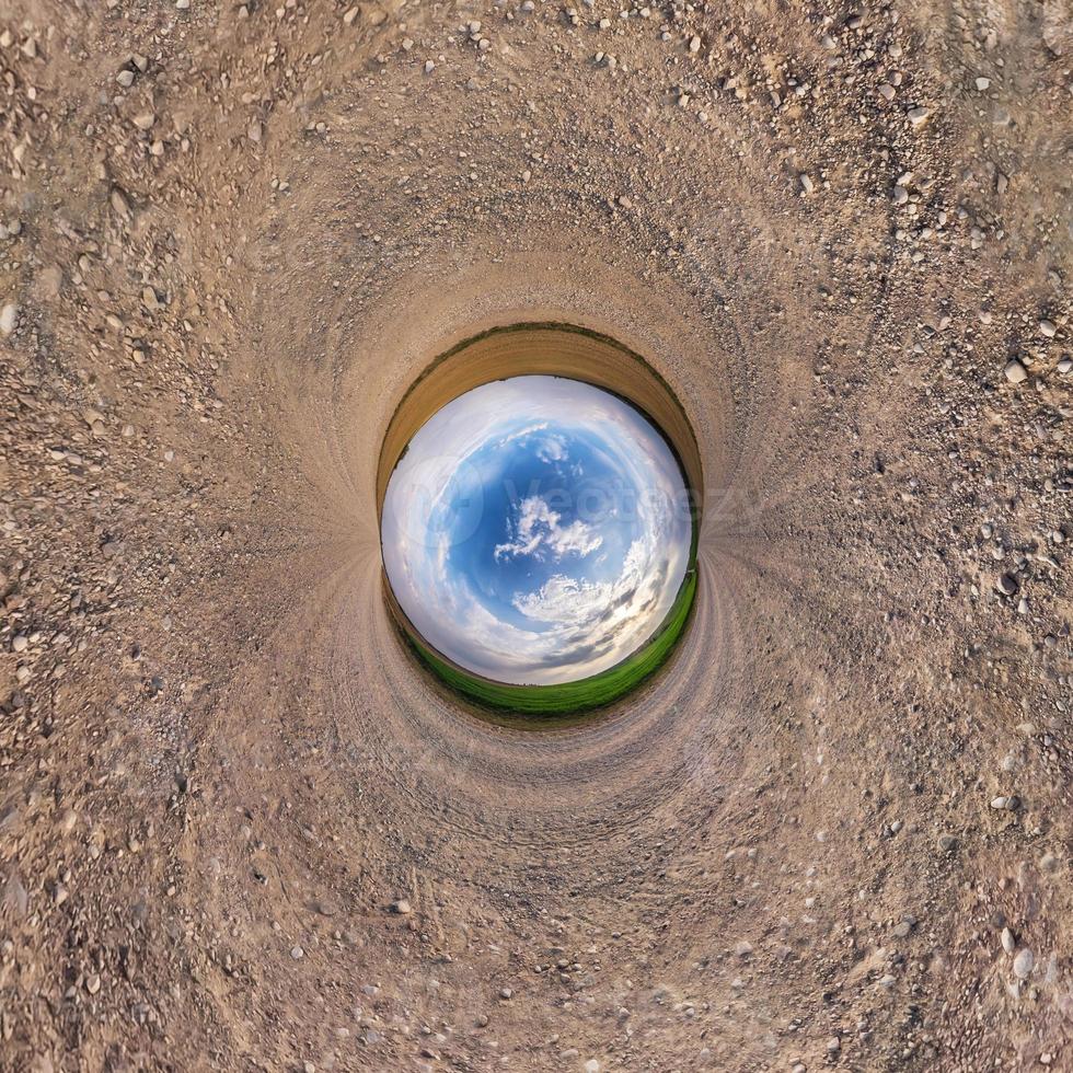 Inversion of little planet transformation of spherical panorama 360 degrees. Spherical abstract aerial view in field with awesome beautiful clouds. Curvature of space. photo