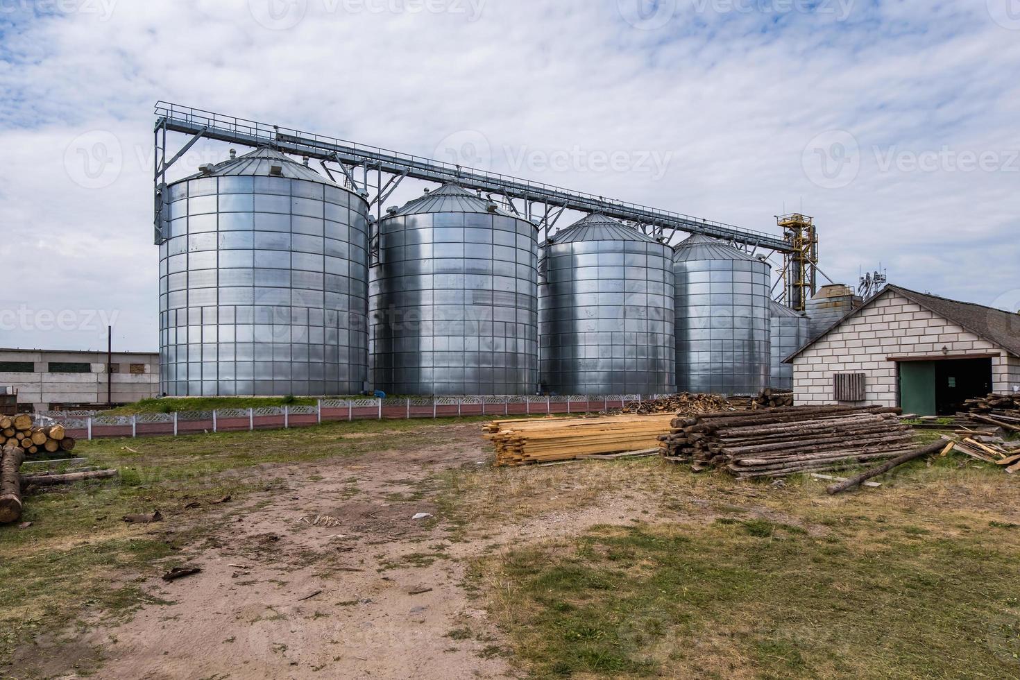 Modern Granary elevator. Silver silos on agro-processing and manufacturing plant for processing drying cleaning and storage of agricultural products, flour, cereals and grain. photo