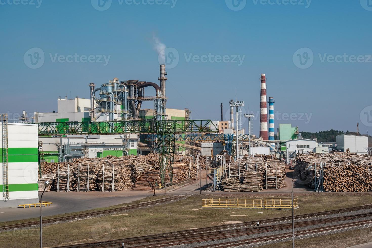 pipes of woodworking enterprise plant sawmill near river. Air pollution concept. Industrial landscape environmental pollution waste of thermal power plant photo