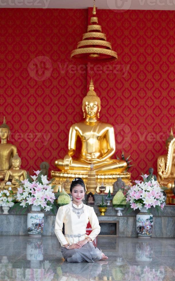 A woman wearing Thai clothes honoring the Sawasdee symbol. photo