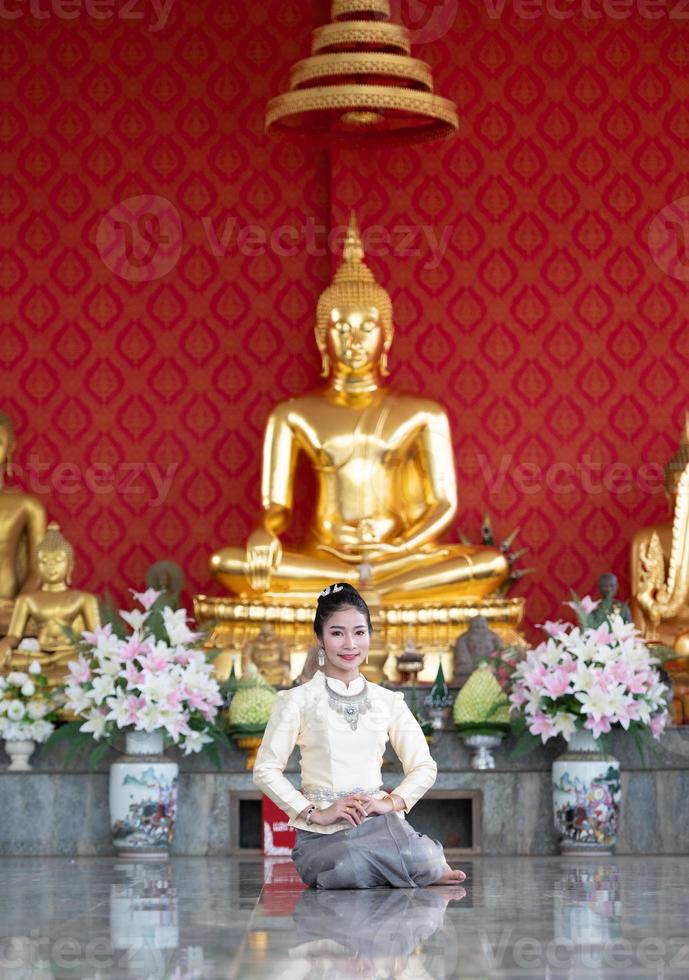 A woman wearing Thai clothes honoring the Sawasdee symbol. photo