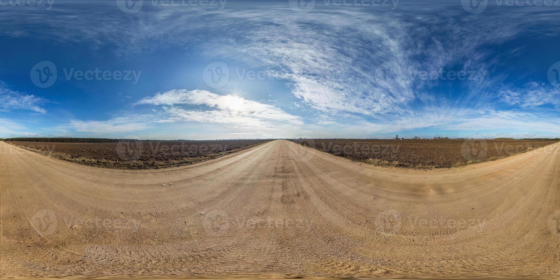 panorama hdri esférico completo sin costuras vista en ángulo de 360 grados en camino de grava entre campos en primavera con impresionantes nubes en proyección equirectangular, listo para contenido de realidad virtual vr ar foto