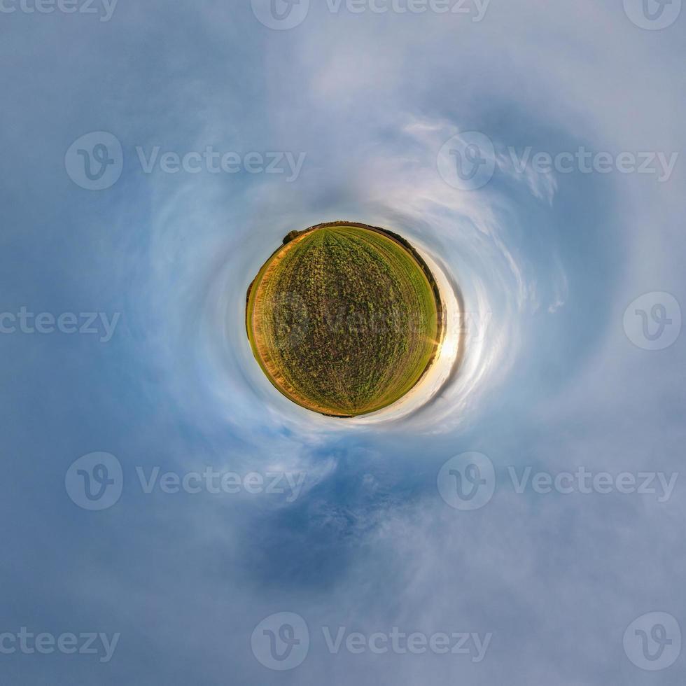 Little planet transformation of spherical panorama 360 degrees. Spherical abstract aerial view in field with awesome beautiful clouds. Curvature of space. photo