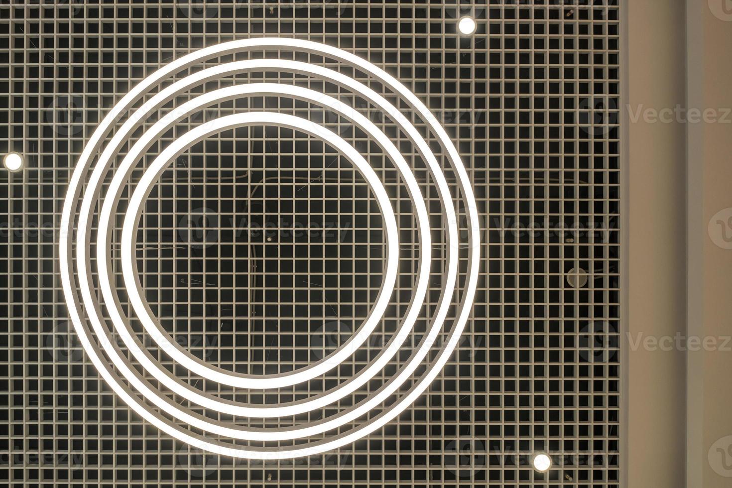 look up on suspended ceiling with round halogen spots lamps and drywall construction in empty room in apartment or house. photo