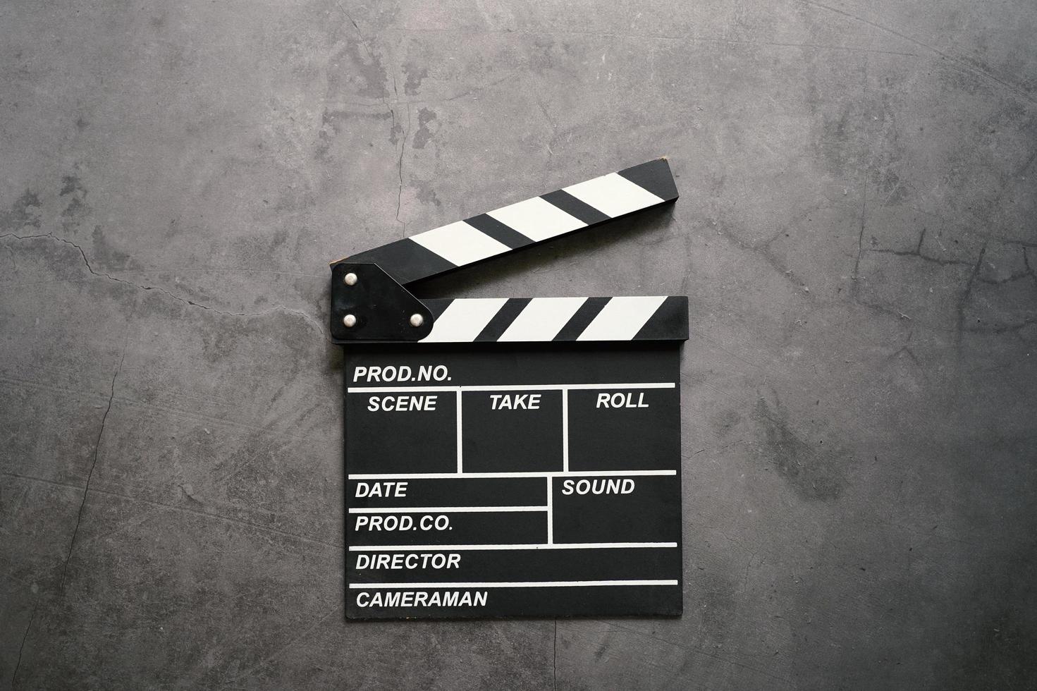 Empty clapperboard in flat lay style on dark stone background, entertainment and cinema industry photo