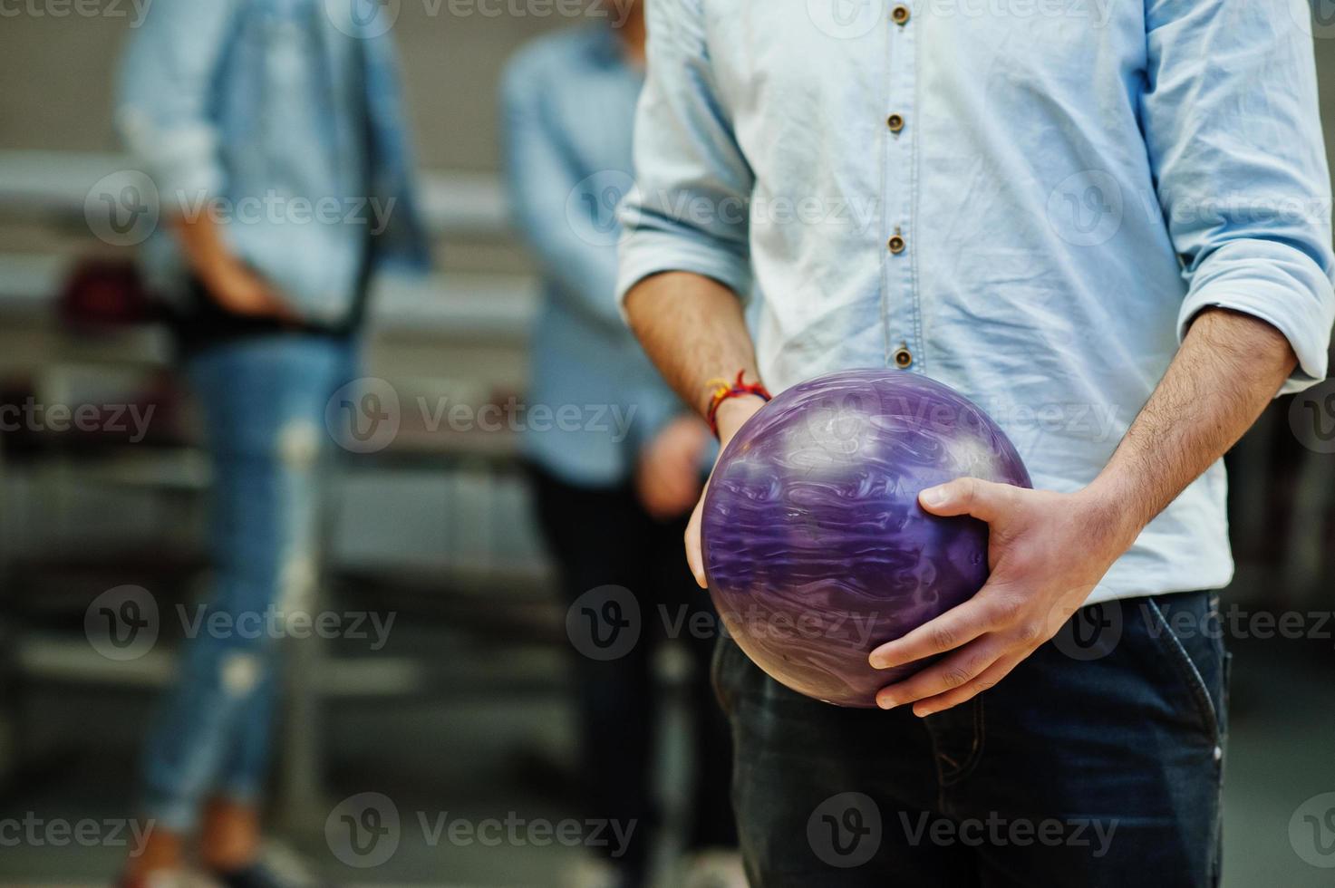 Close up purple bowling ball on hands of player. photo