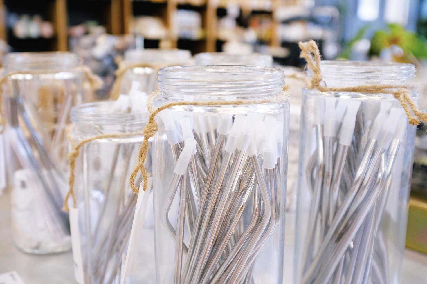 Reusable stainless straw for drink in glass of jar for selling, sustainable products, zero waste concept photo