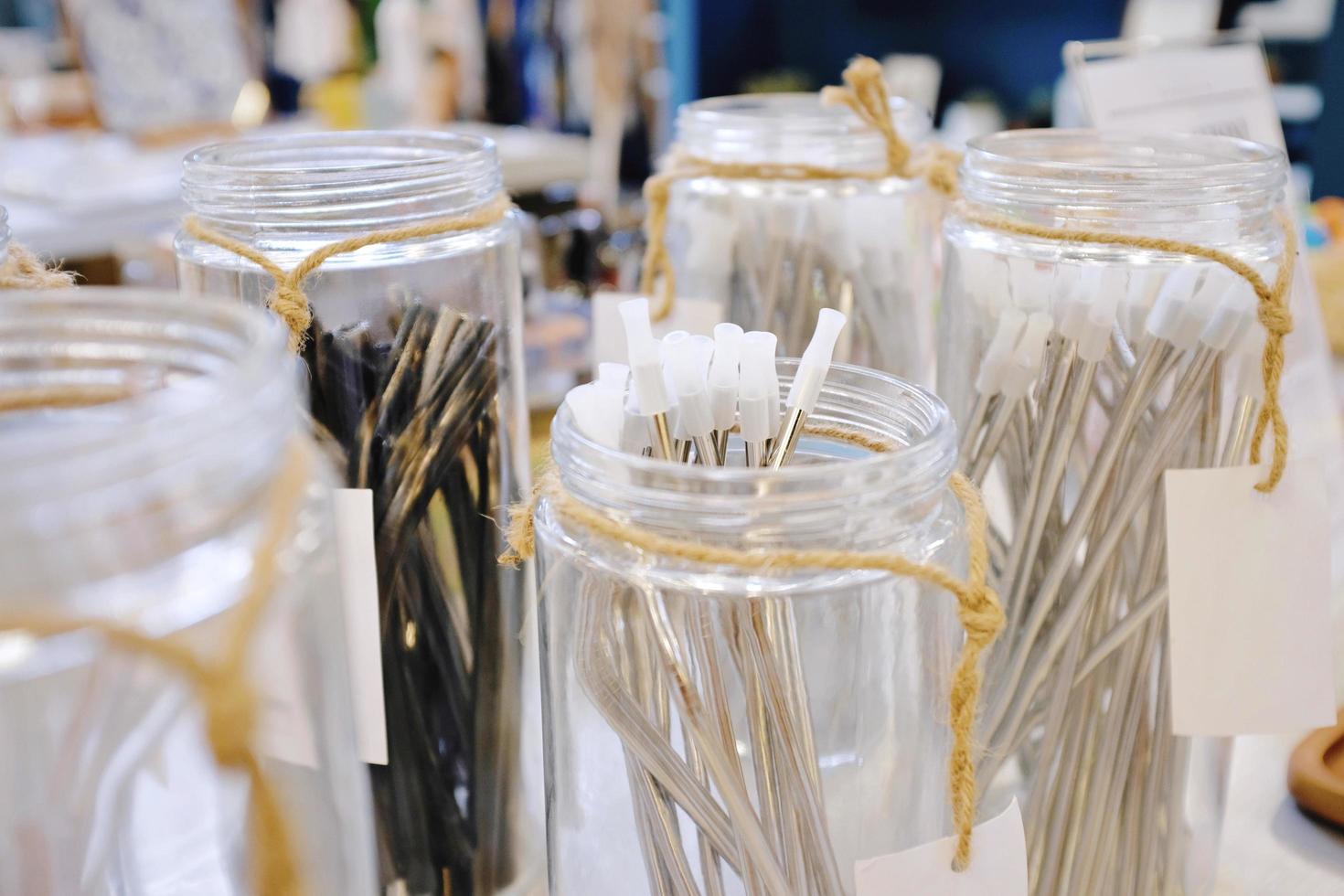 Reusable stainless straw for drink in glass of jar for selling, sustainable products, zero waste concept photo