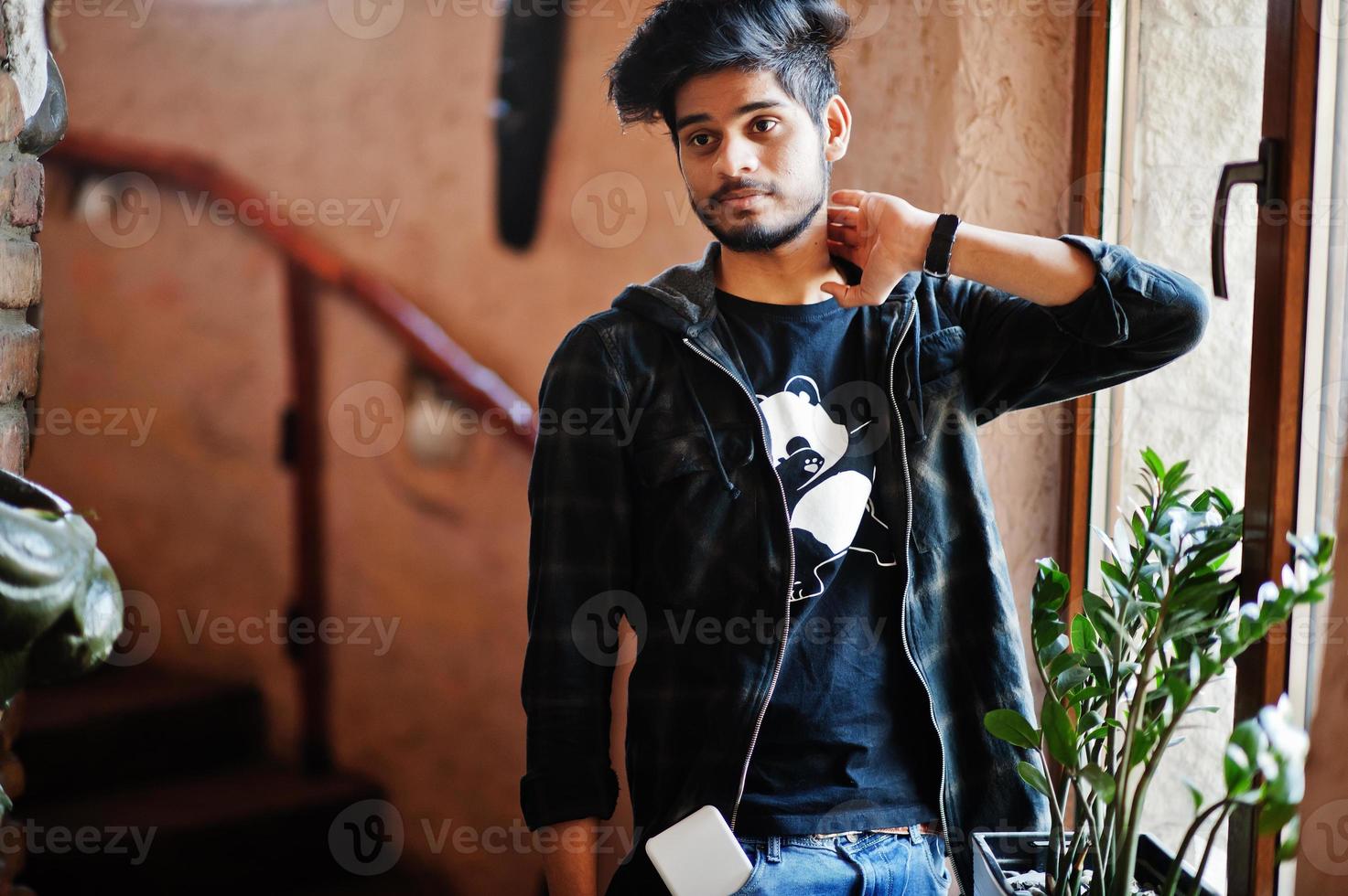 Beard asian man in casual wear stand inside house on stairs against window. photo