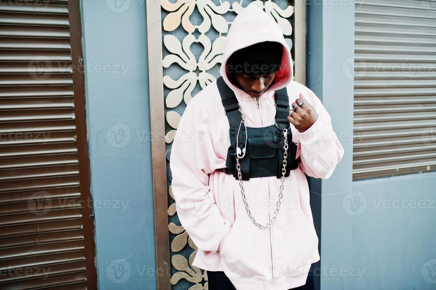 Stylish urban style african american man in pink hoodie posed. Afro rapper guy. photo