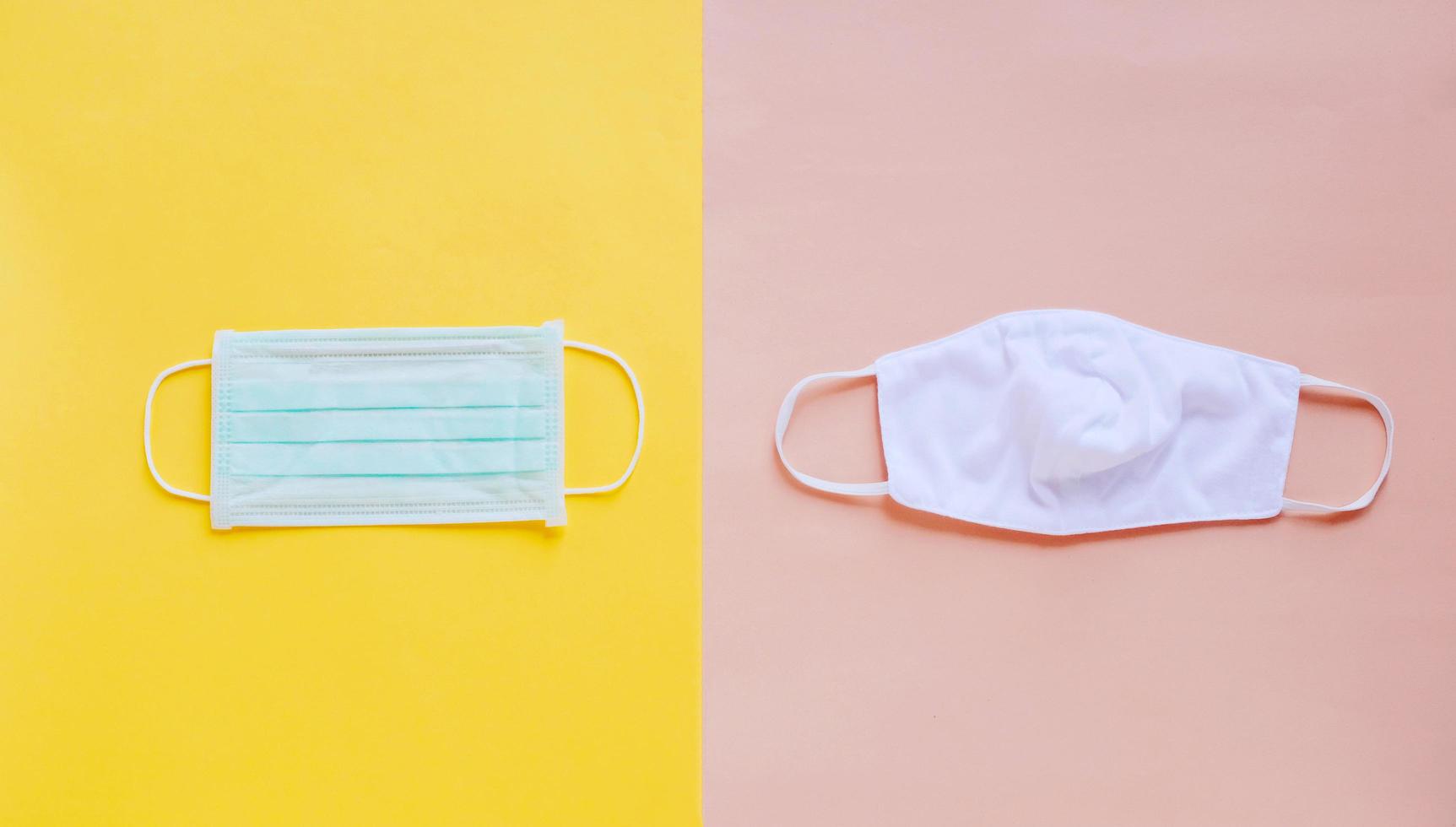 Flat lay of two different kind of medical mask and fabric mask on bright yellow and orange background, health care and prevent the spread of pandemic Covid-19 and Coronavirus, photo