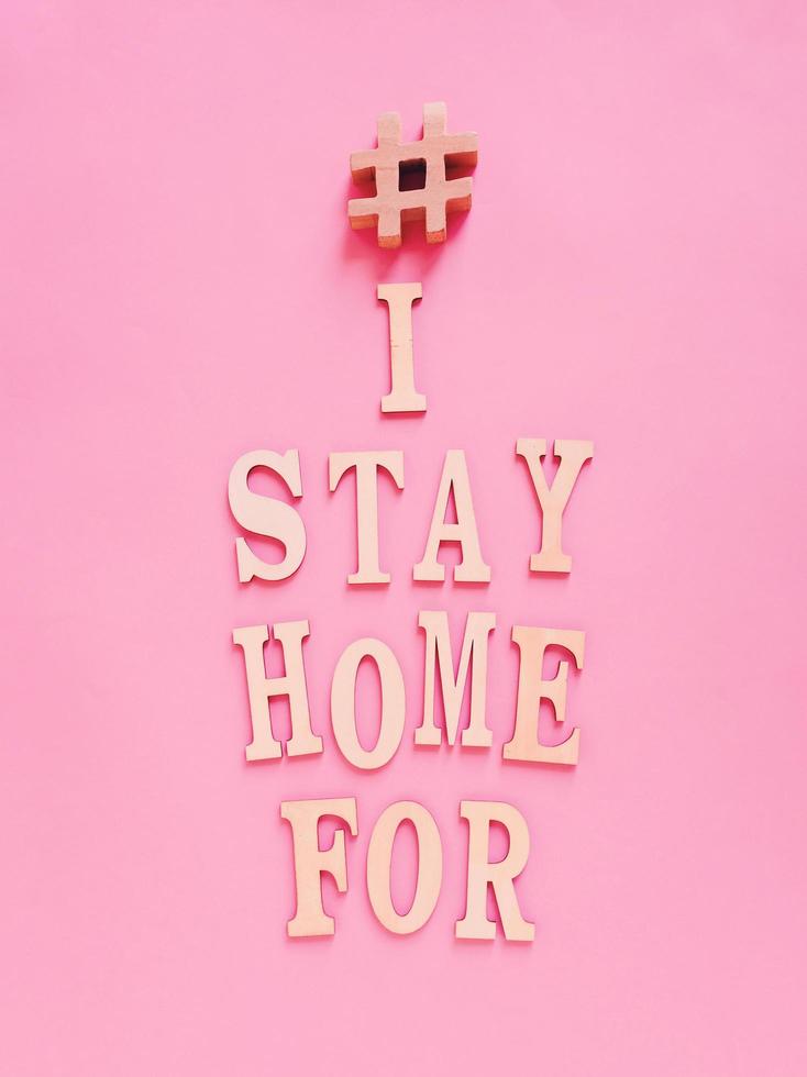 Flat lay of alphabet wooden letter about trending hashtag I stay home for concept on bright pink background, self isolation and prevent the spread of pandemic Covid-19 and Coronavirus, photo