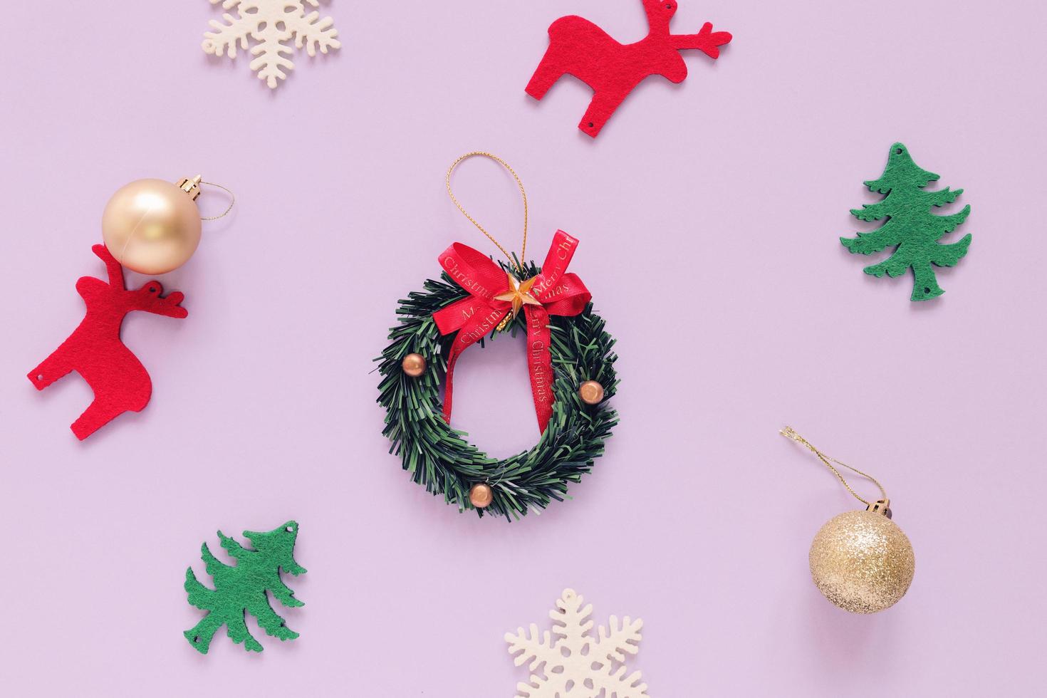 Flat lay of Christmas ornaments on purple background with minimal style photo