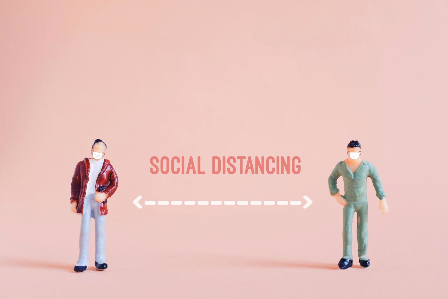 Social distance concept, miniature people standing keep distance and wearing mask in public to protect from Covid-19 and Coronavirus, prevention the outbreak spreading photo
