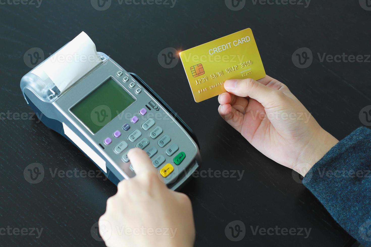 A woman using hand credit card swipe machine for sell products in the shop. Concept of spending via credit card. photo