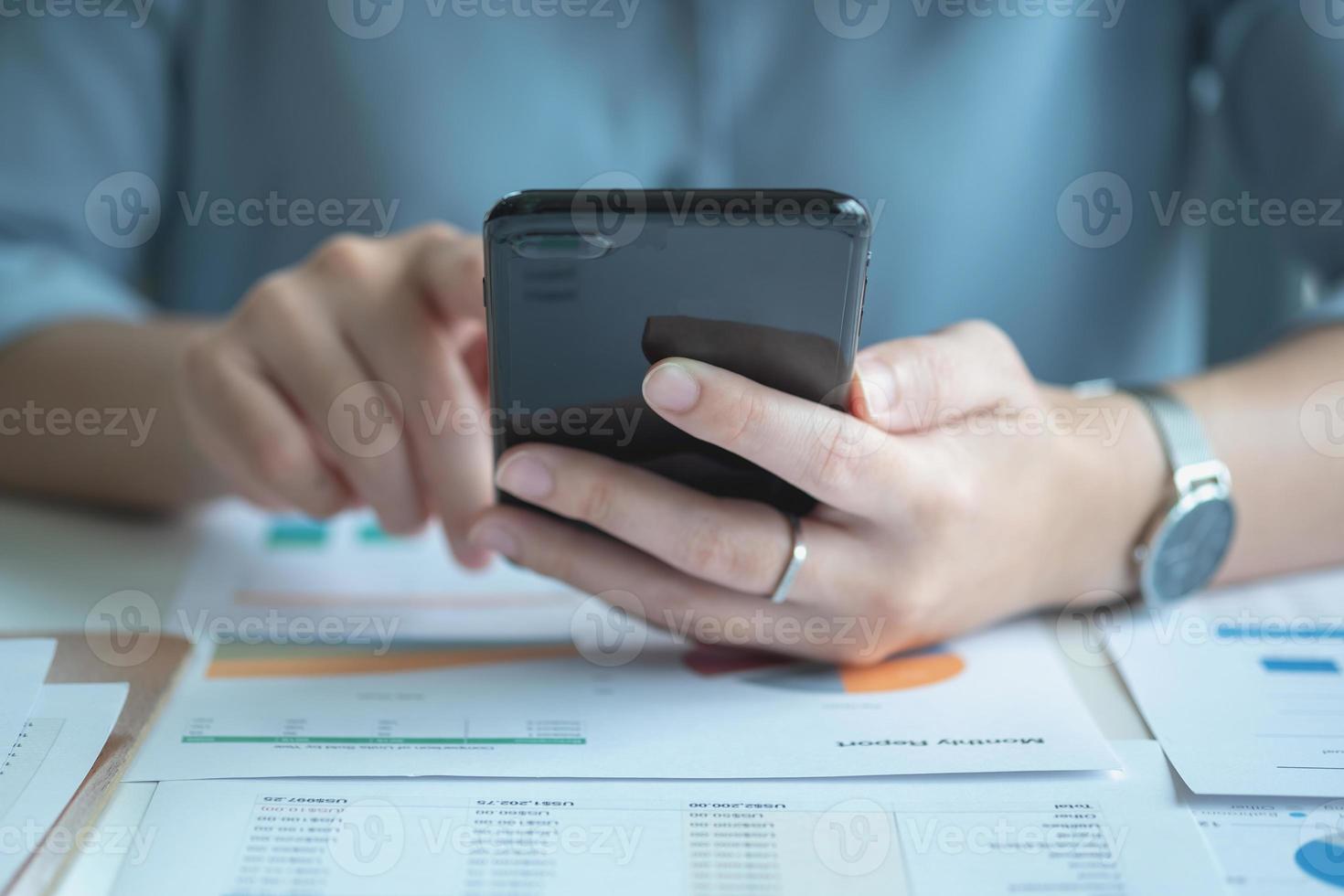 An Asian businesswoman uses a mobile phone to contact a customer to inform her of the company's business partnership. photo