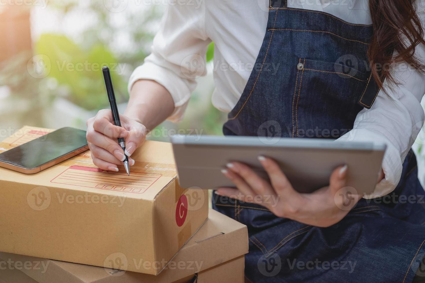 Young businesswoman using a tablet to check online product sales photo