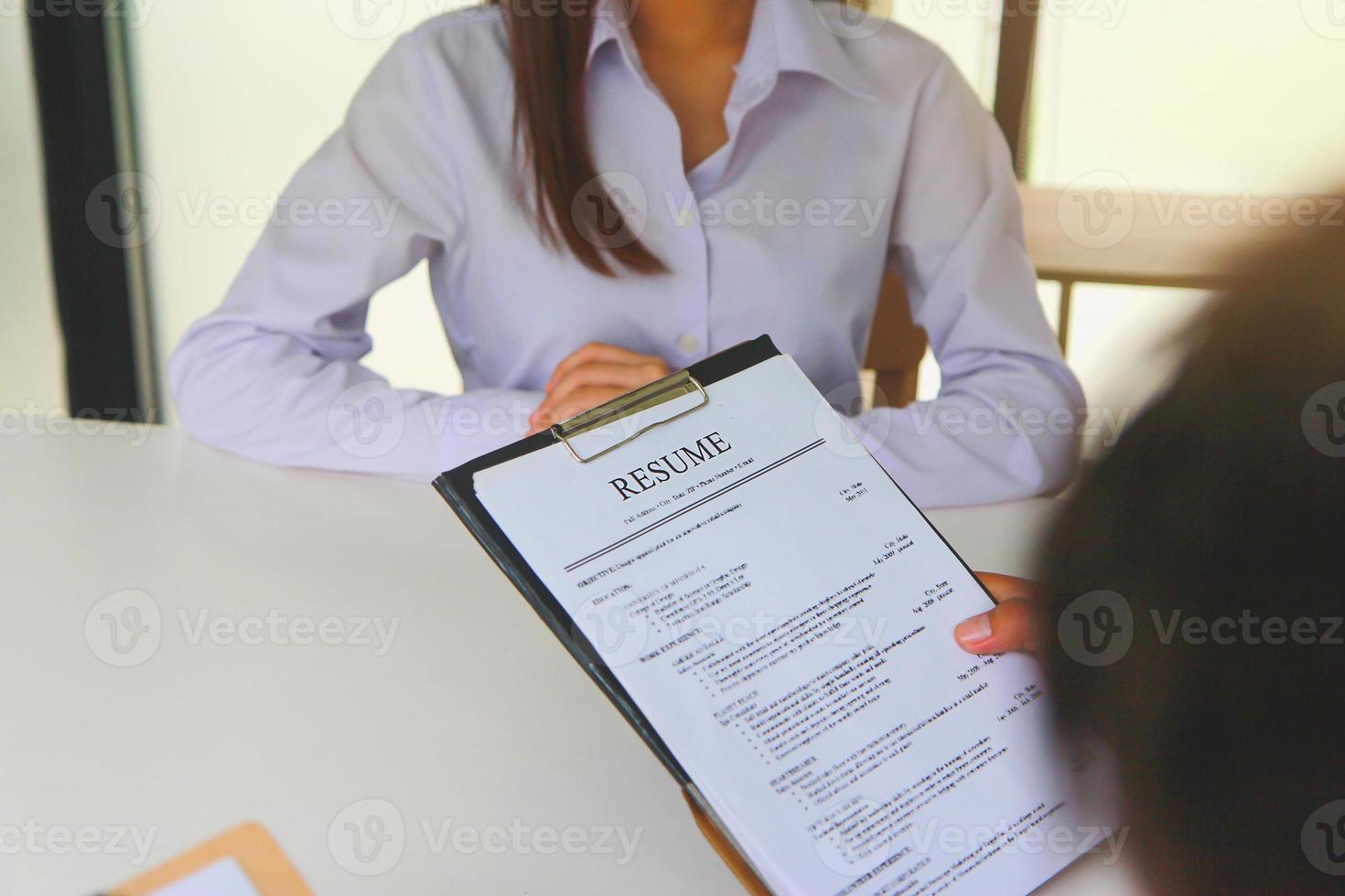 vista de primer plano de las entrevistas de trabajo de la oficina con el personal de recursos humanos que tiene currículum y verificaciones de antecedentes de los solicitantes con habilidades preparadas. foto