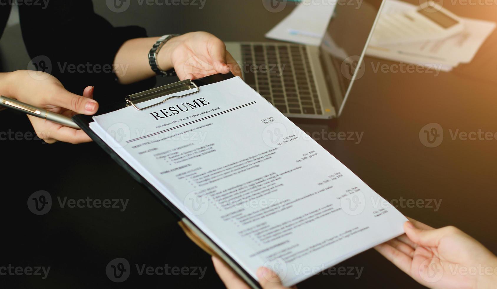 A young woman sends a resume to a human resource manager to consider the application. The human resource manager makes hiring decisions. Interview concept. photo