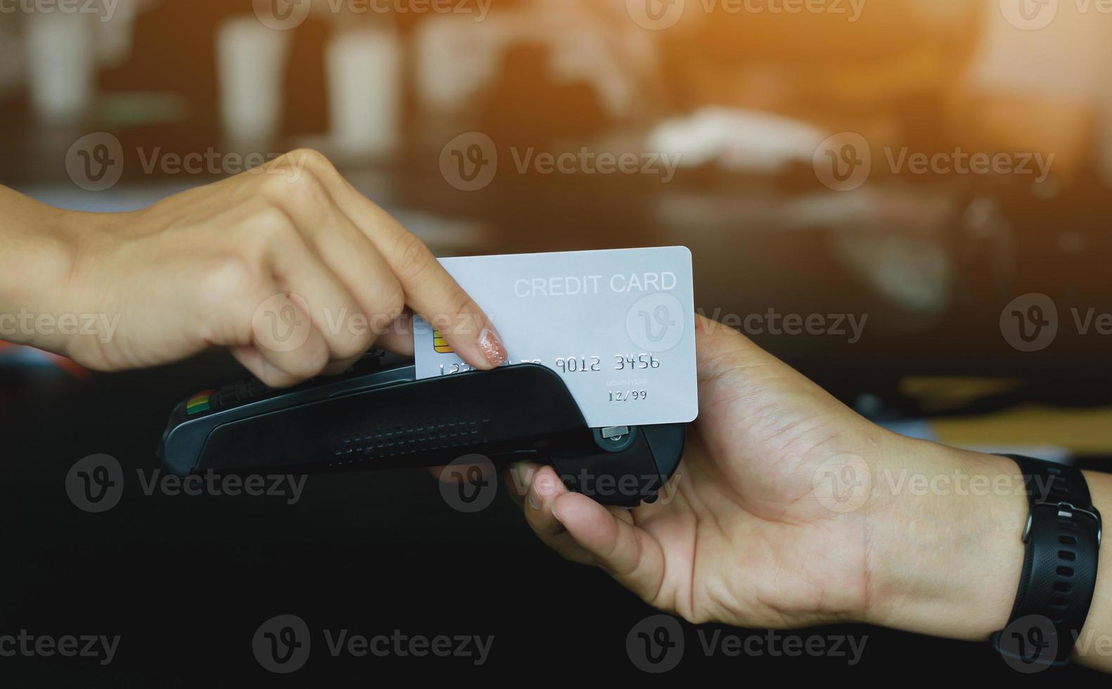 Man using credit card swipe machine for sell products in the shop to customers. Concept of spending via credit card. photo