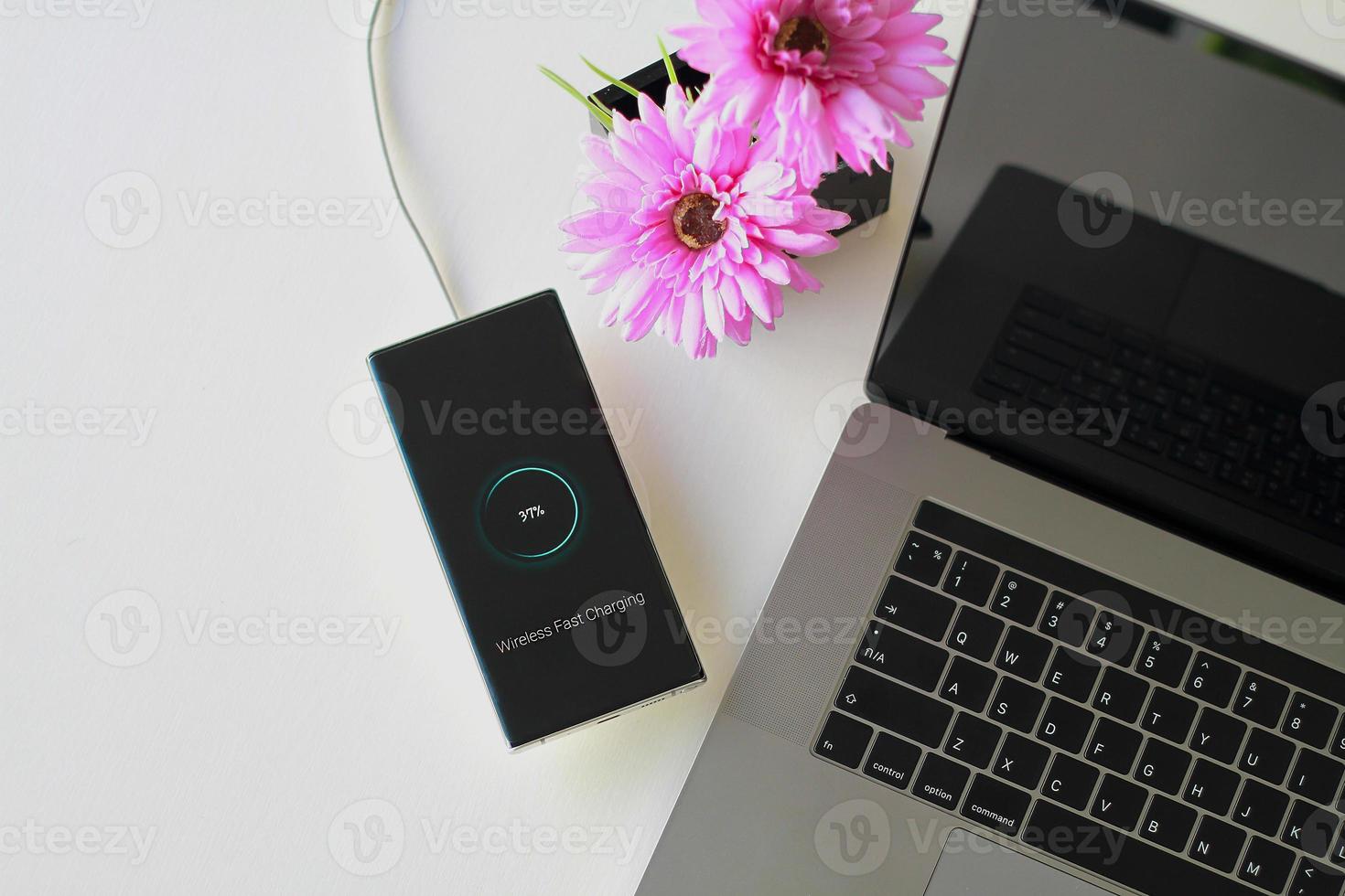 Smartphone wireless charging using wireless charging pad new technology at office. photo