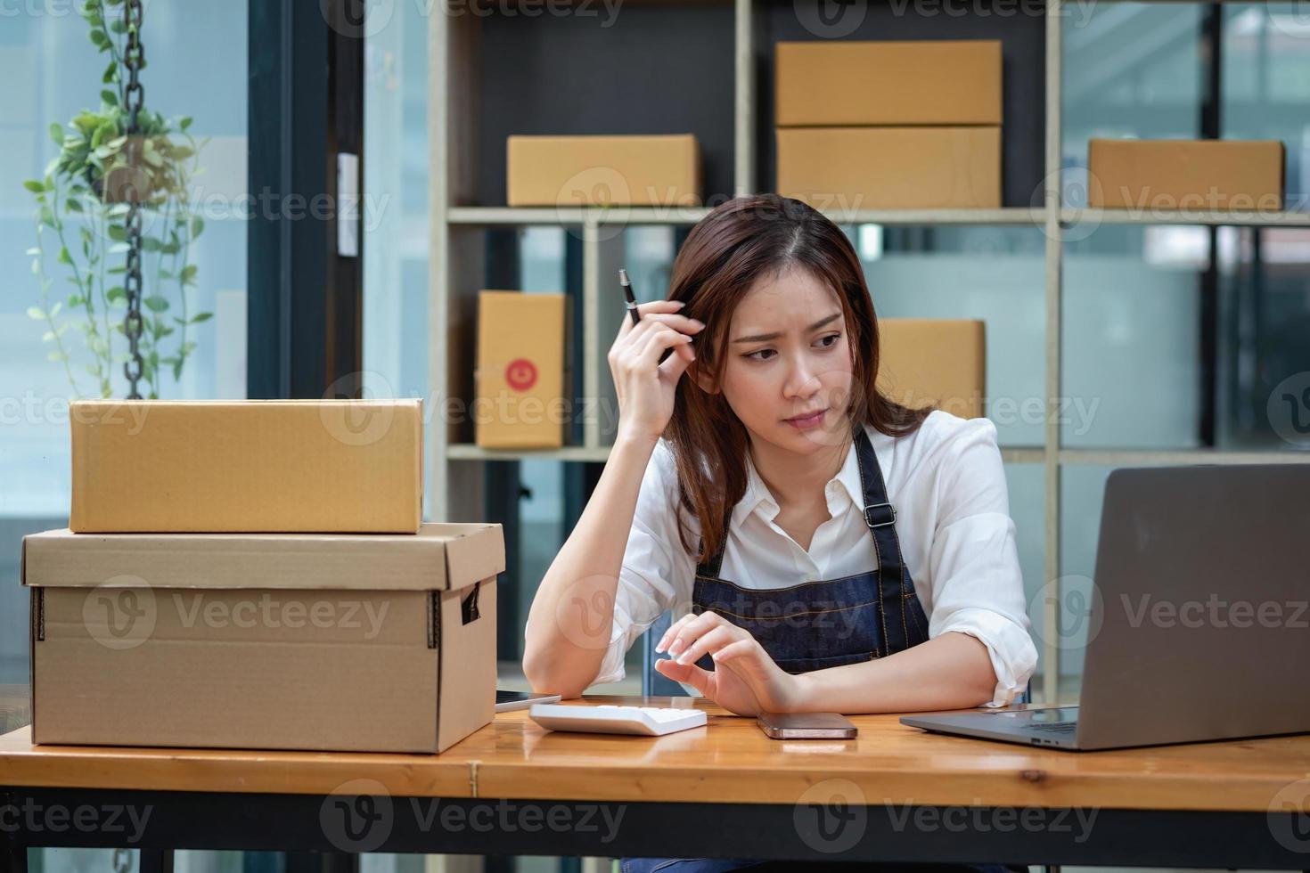 mujer de negocios asiática preocupada por las ventas en línea desordenadas foto